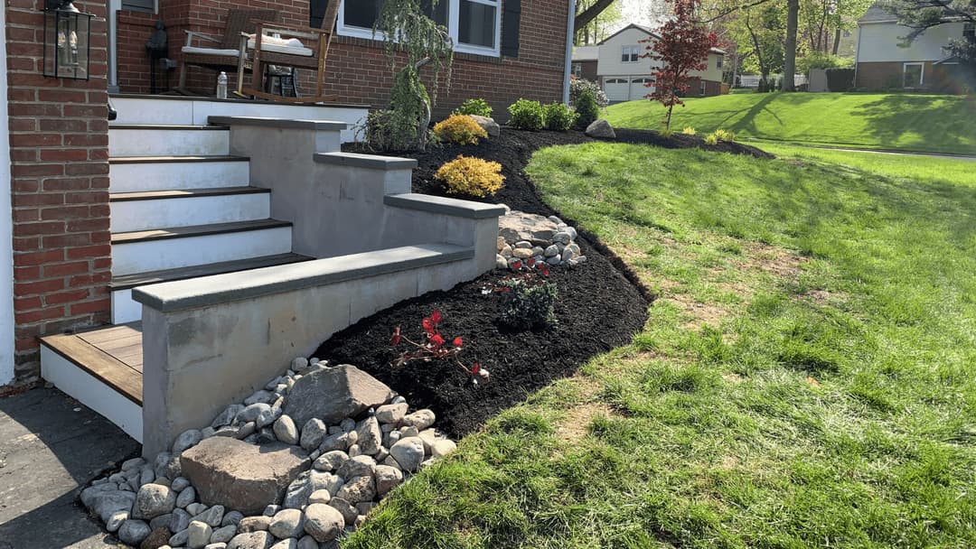 Front yard landscaping with steps, rocks, and colorful plants, enhancing curb appeal.