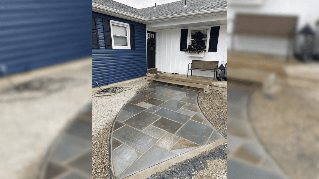 Stylish curved stone walkway leading to a modern blue and white home entrance.