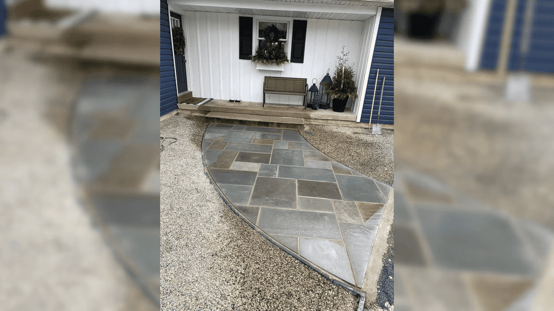 Curved stone pathway leading to a home entrance with a blue and white exterior.