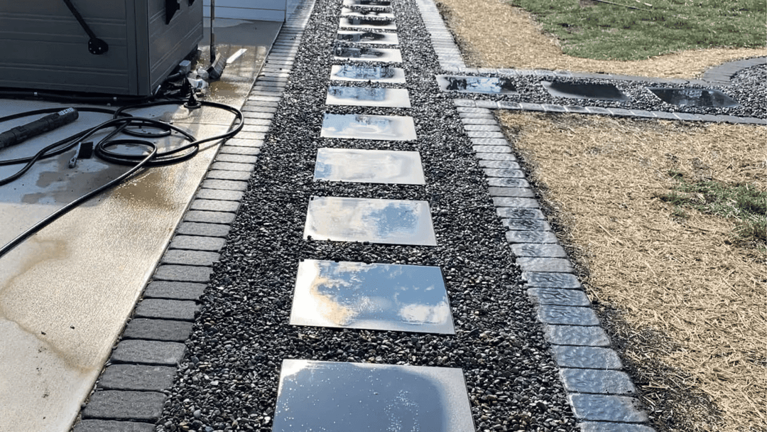 Modern garden pathway with polished stone slabs surrounded by decorative gravel and landscaping.