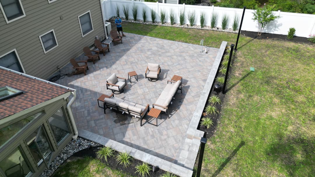 Aerial view of a landscaped backyard patio with seating and a lawn area.